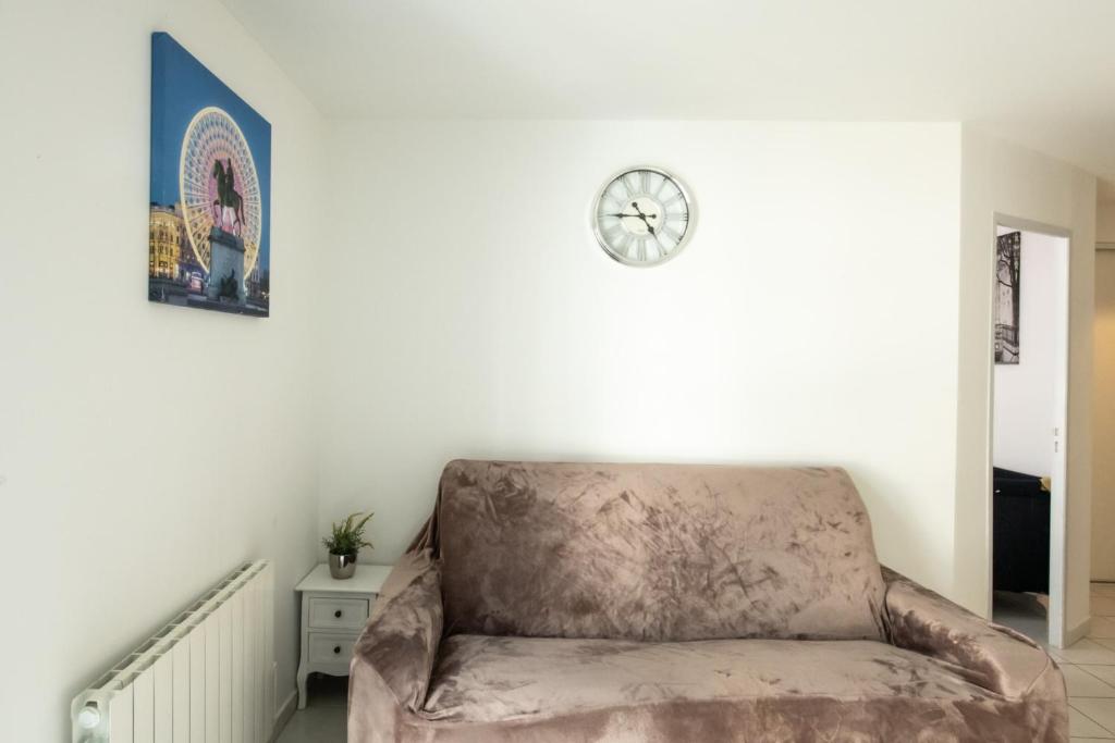 a chair in a room with a clock on the wall at Le Casper - Charmant appartement au calme proche centre-ville in Lyon