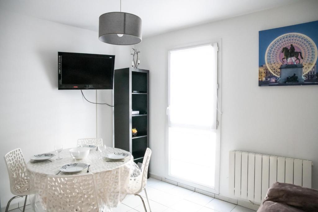 a white dining room with a table and chairs at Le Casper - Charmant appartement au calme proche centre-ville in Lyon
