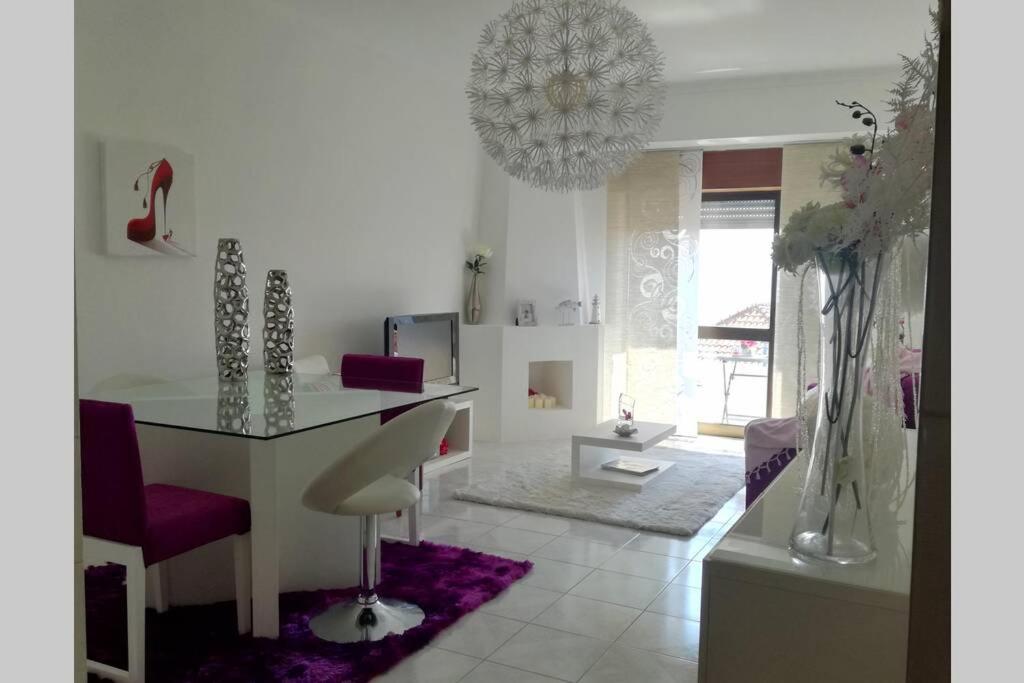 ein Wohnzimmer mit einem Tisch und einem lila Teppich in der Unterkunft LightHouse - Rest, Love and Dream in Nazaré