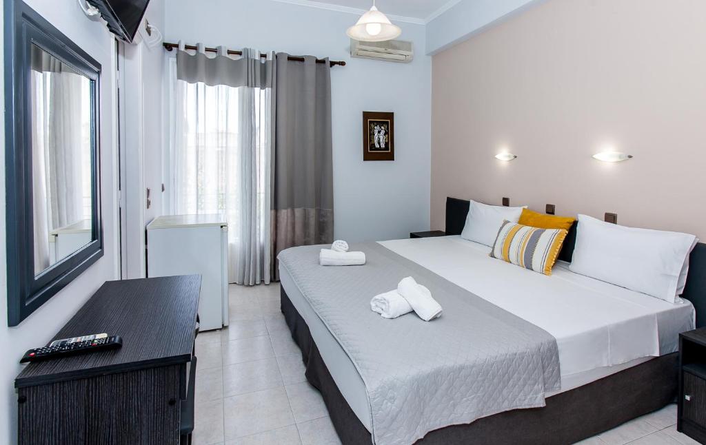 - une chambre avec un grand lit et des serviettes dans l'établissement Hotel Electra, à Tolón