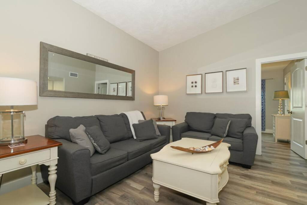 a living room with a couch and a table and a mirror at Siesta Key Village-Suite #3: A Block to the Beach! in Sarasota