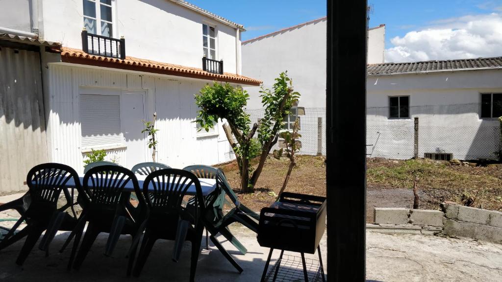 a group of chairs and a table in a yard at Casa Familiar con barbacoa in Finisterre