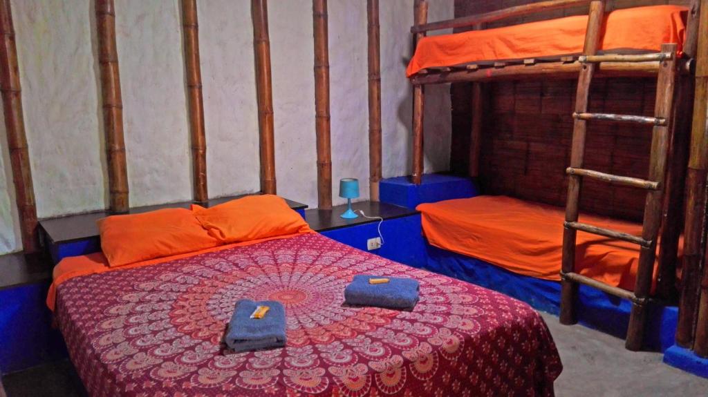 a bedroom with a bed and two bunk beds at Saigon Backpackers hostel in Máncora