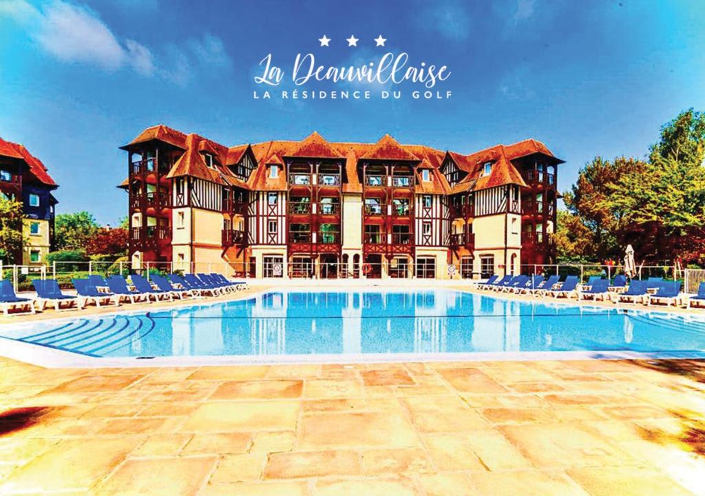 un grand hôtel avec une piscine et des chaises dans l'établissement La Deauvillaise - Résidence du Golf, à Deauville