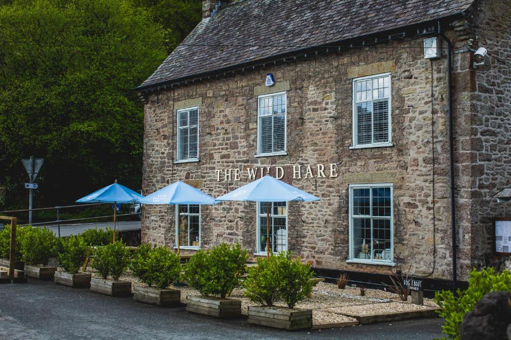 a brick building with umbrellas in front of it at The Wild Hare Tintern in Tintern