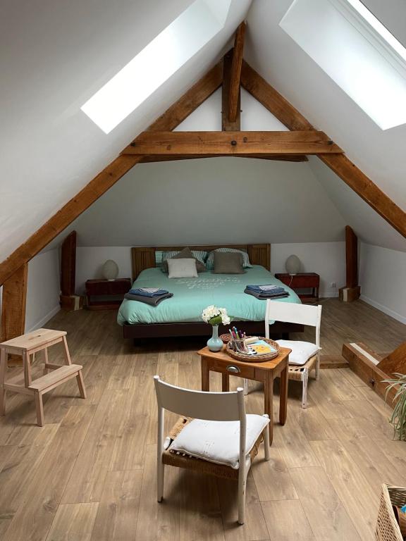 Schlafzimmer mit einem Bett, einem Tisch und Stühlen in der Unterkunft Chambre ambiance campagne chic in Freneuse