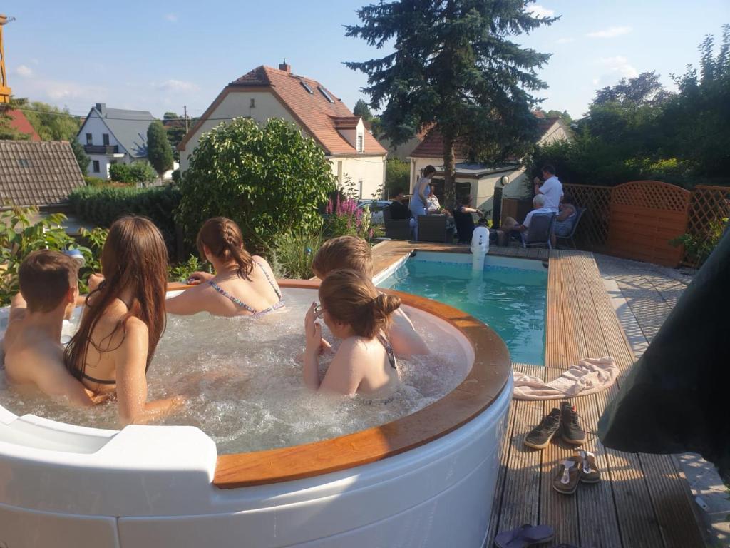 a group of people in a hot tub in a backyard at Ferienwohnung Moritzburg mit Pool in Moritzburg