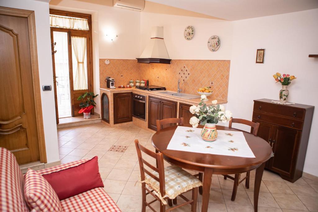 een keuken met een houten tafel en een eetkamer bij Casa Caronia marina near Cefalù in Caronia Marina