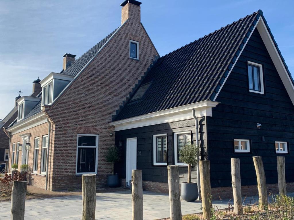 a black house with a gambrel roof at Logies Zen & Zilt Veere in Veere