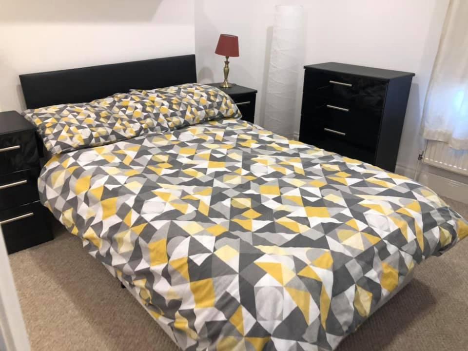 a bedroom with a bed with a yellow and black comforter at forest hill in London