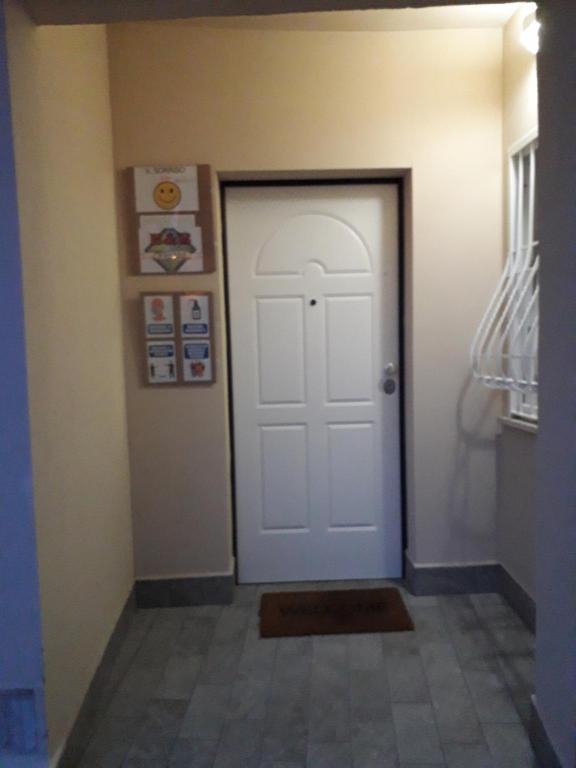 um corredor com uma porta branca e piso em azulejo em b&b Il Sorriso em Pozzilli