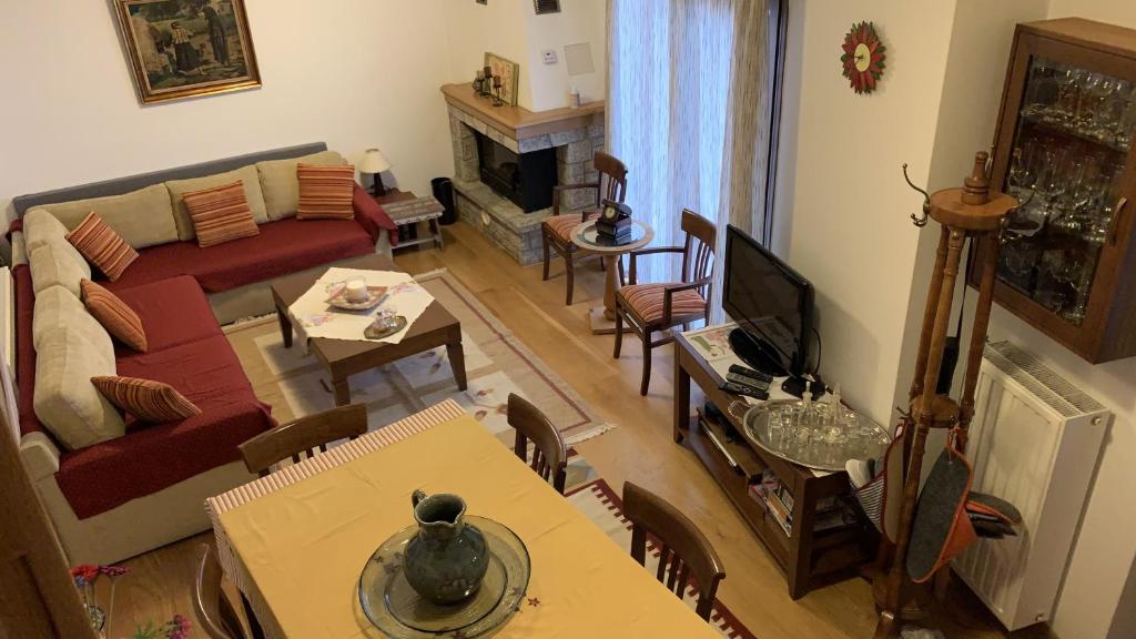 salon z kanapą, telewizorem i stołem w obiekcie Ξύλο & Παράδοση w mieście Pavliani