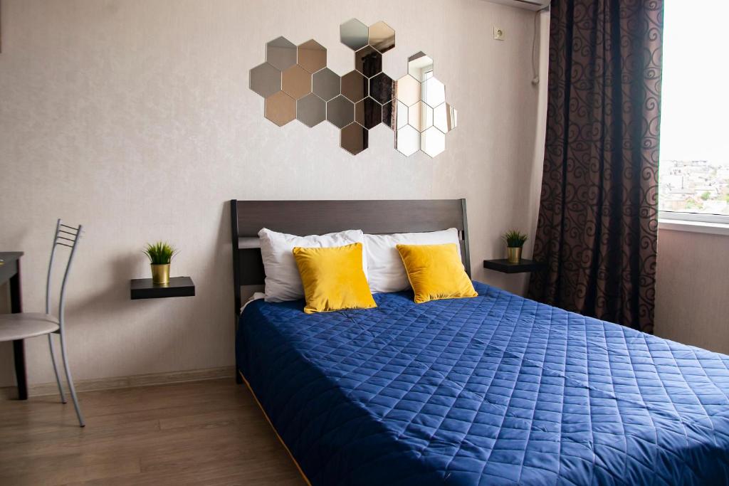 ノヴォロシースクにあるАпартаменты Мильфей 19-3のベッドルーム(青いベッド、黄色い枕付)