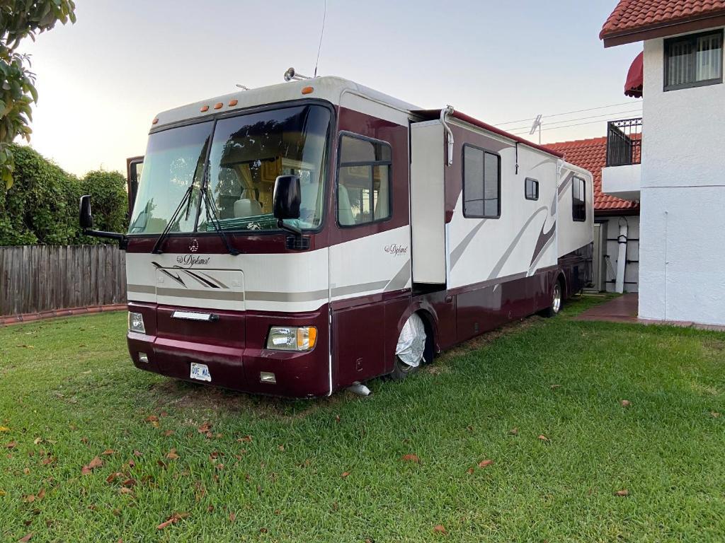 an rv parked in a yard next to a house at Caravana RV in Miami