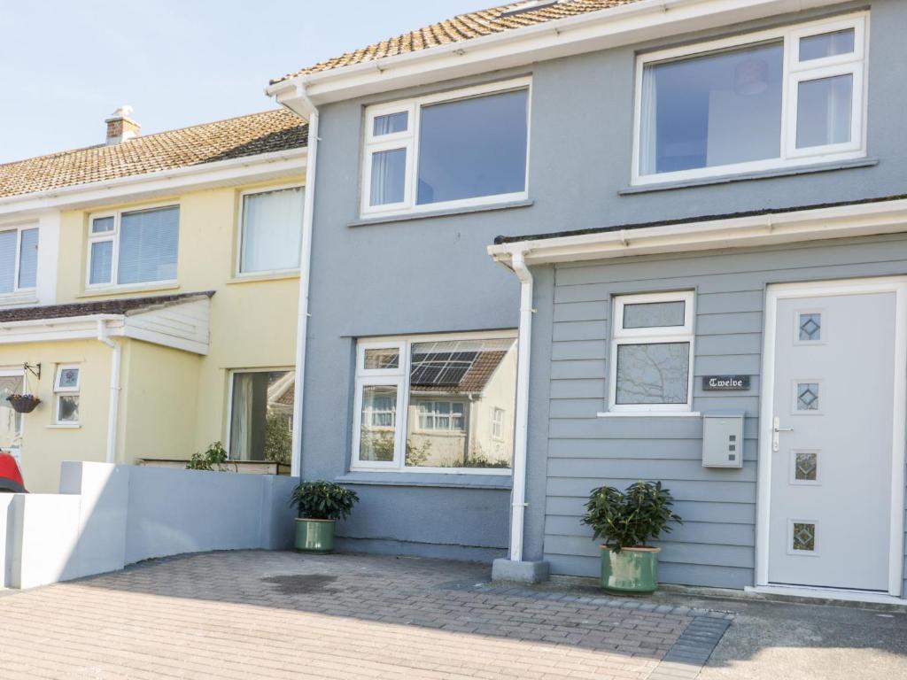 a grey house with a white door at Eloen in Newquay