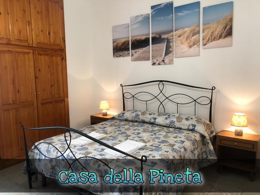 una camera con un letto e due comodini con lampade di Cala Gonone - Casa della Pineta a Cala Gonone