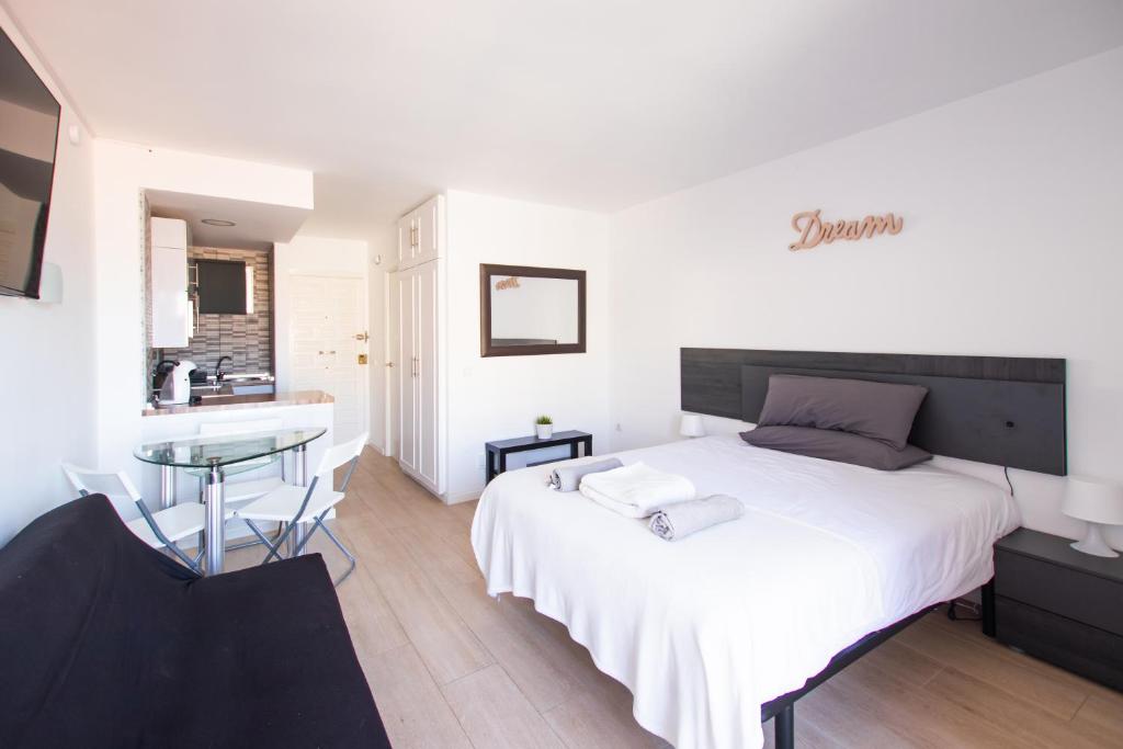 una camera da letto con un grande letto bianco e un tavolo di Dream Studio in Benalmadena Costa del Sol a Benalmádena