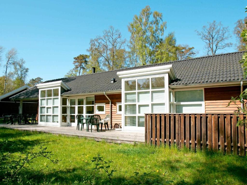 une maison en rondins avec une terrasse et une table dans l'établissement 10 person holiday home in Hasle, à Hasle