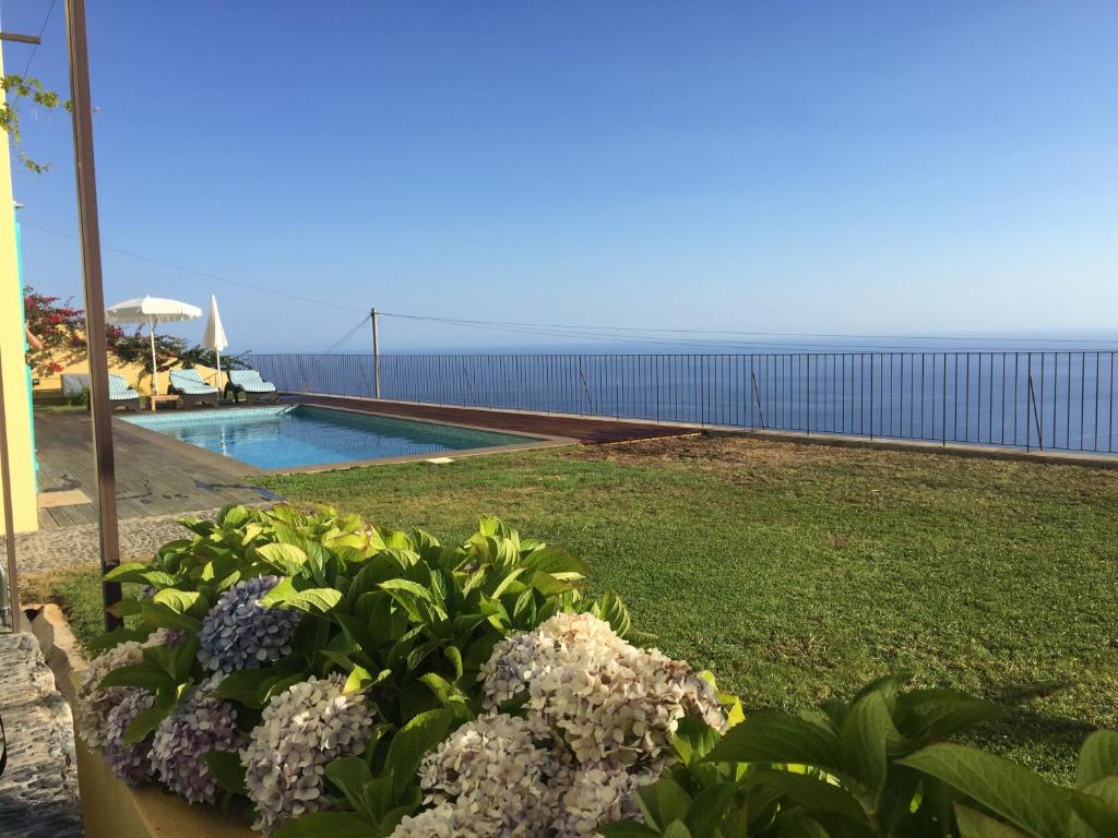 a garden with a view of the ocean at Villa Pargo in Fajã da Ovelha