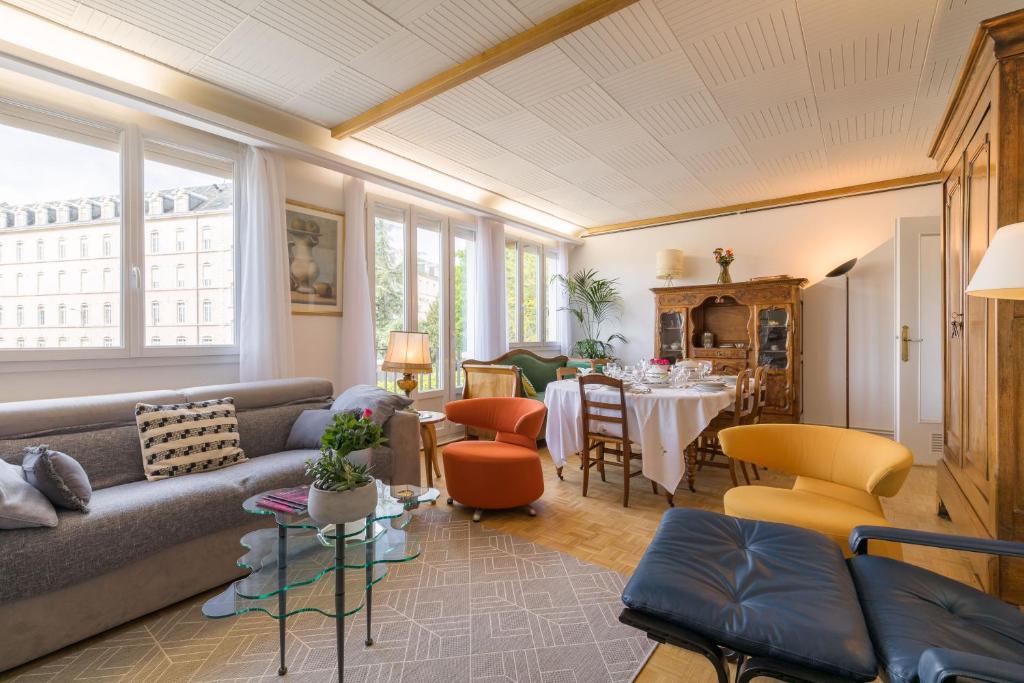 sala de estar con sofá y mesa en Appartement Climatisé 100M2 7mn Centre Ville Garage 5Pièces 5 Adultes Bébé Arrivée Autonome, en Dijon