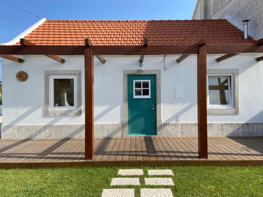 een huis met een groene deur op een terras bij Casa da Avó in Sesimbra