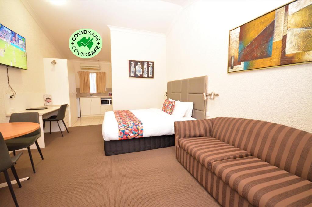 Habitación de hotel con sofá y cama en Boulevarde Motor Inn, en Wagga Wagga