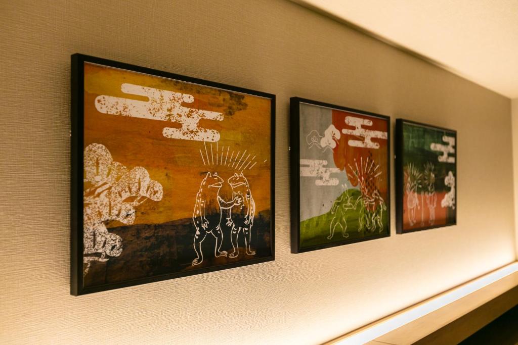 three framed pictures on a wall in a room at Hotel Forza Osaka Namba in Osaka