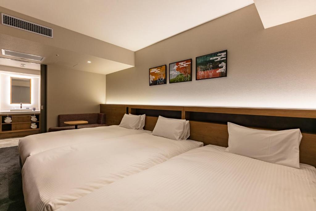 two beds in a hotel room with two bedsvisor at Hotel Forza Osaka Namba in Osaka