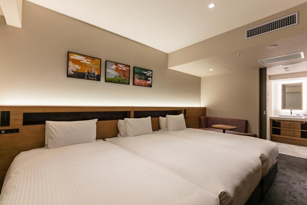 a bedroom with two beds and a window at Hotel Forza Osaka Namba in Osaka
