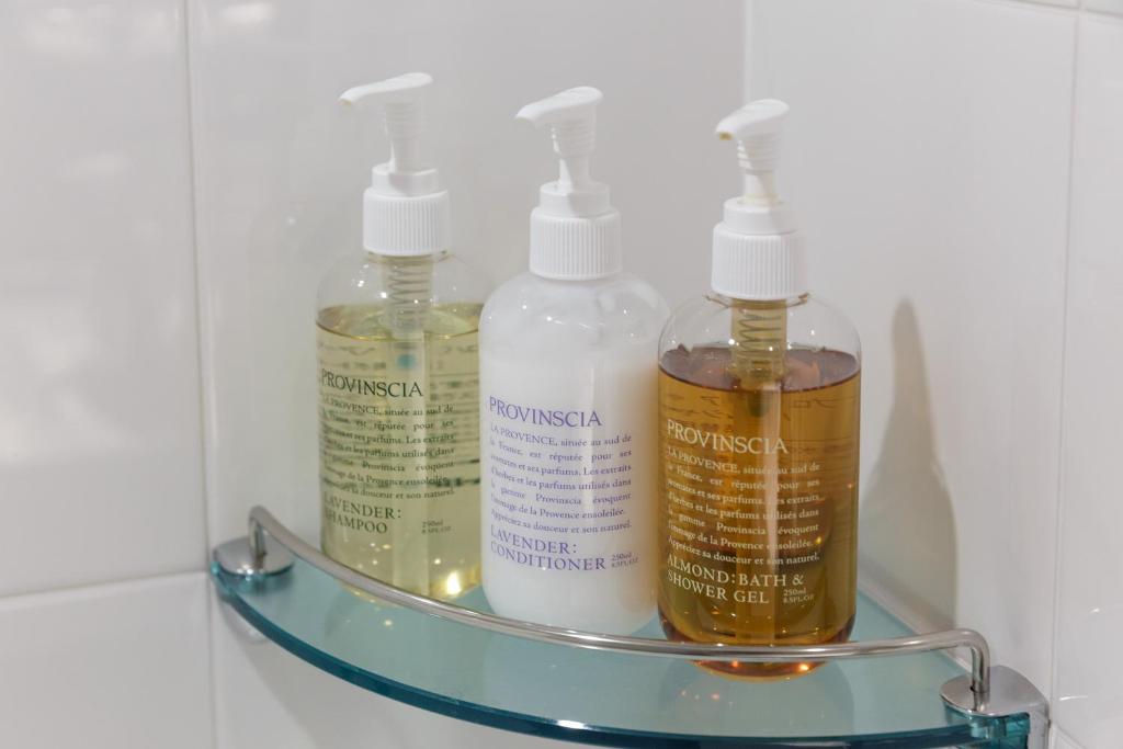 a glass shelf with three bottles on it at Hotel Forza Osaka Namba in Osaka