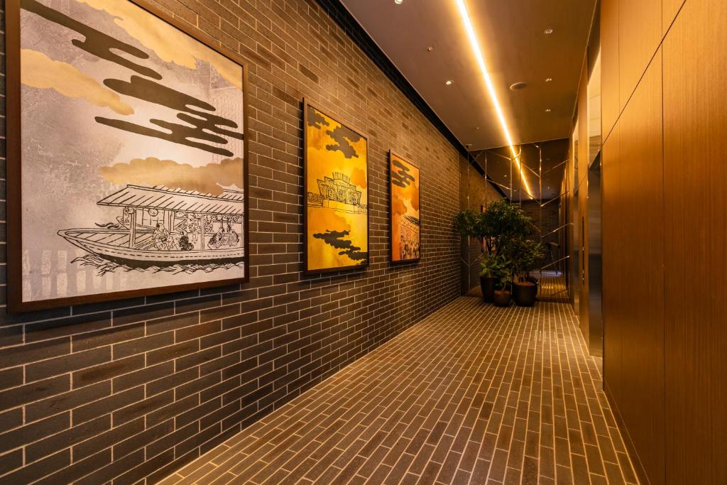 a hallway with paintings on the walls of a building at Hotel Forza Osaka Namba in Osaka