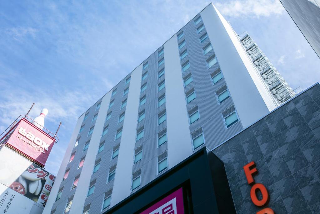 a tall building with a sign in front of it at Hotel Forza Osaka Namba in Osaka