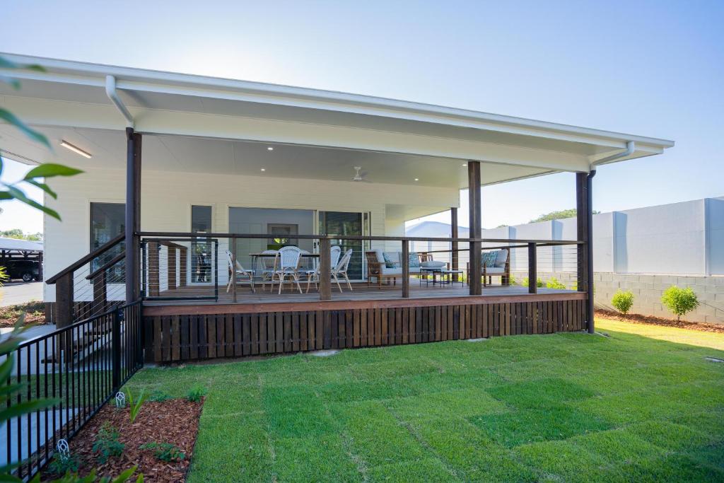 a home with a large deck with chairs on it at Crab Cottages in Urangan