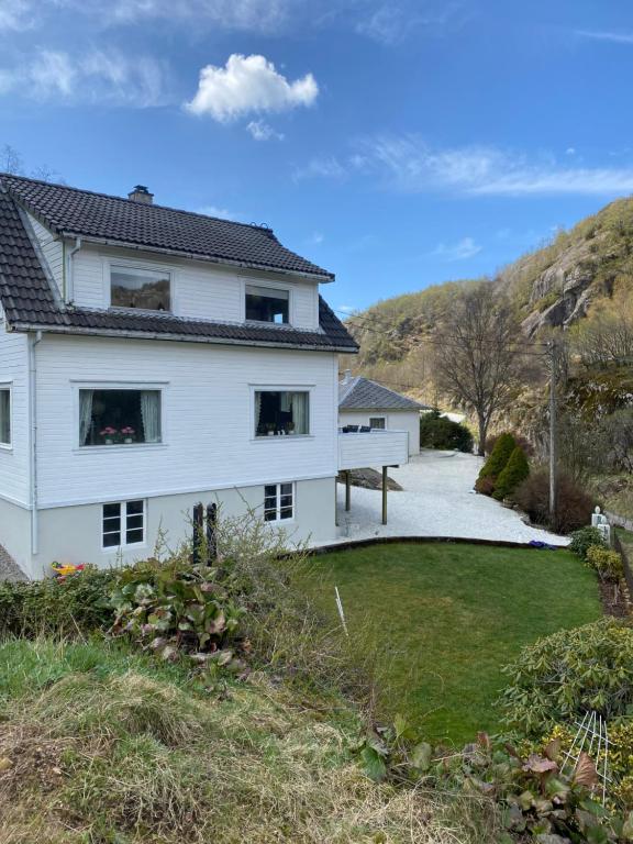 een wit huis op een heuvel met een tuin bij Sokndal - Cozy vacation home in peaceful surroundings in Ålgård