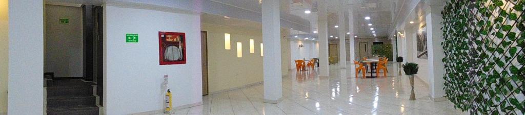 a hallway of a building with tables and chairs at Hotel Paradise del Cafe in Pereira