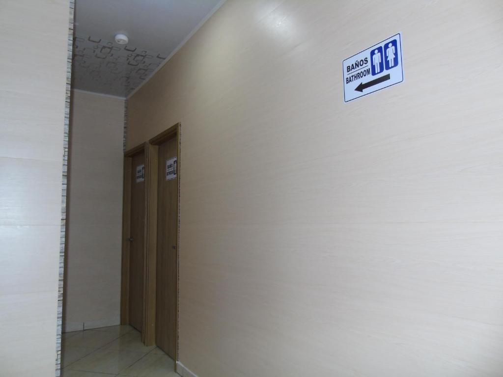 a sign on the wall of a hallway with two doors at Hotel Paradise del Cafe in Pereira