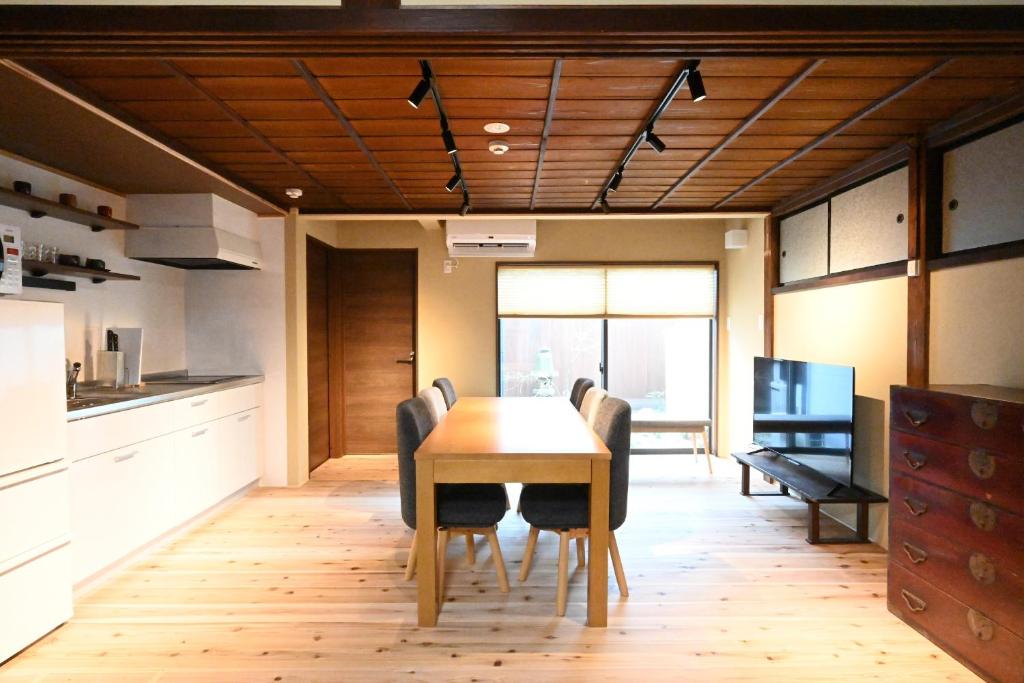 a kitchen and dining room with a table and chairs at Manabi-stay Matsue 駅近伊勢宮町どこに行くにも最高に便利な古民家一棟貸切ホテル in Matsue