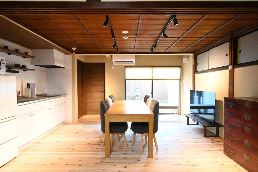 una cucina e una sala da pranzo con tavolo e sedie di Manabi-stay Matsue 駅近伊勢宮町どこに行くにも最高に便利な古民家一棟貸切ホテル a Matsue