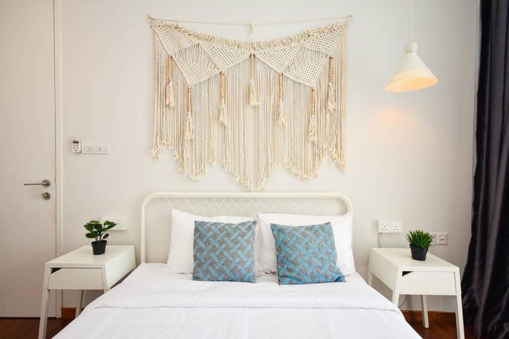 una camera da letto con un letto bianco con due tavoli bianchi di D'Bohemia Suite by Nest Home 【Paradigm Mall】 a Petaling Jaya