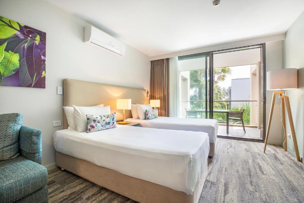a hotel room with two beds and a couch at Narrabeen Sands Hotel by Nightcap Plus in Narrabeen