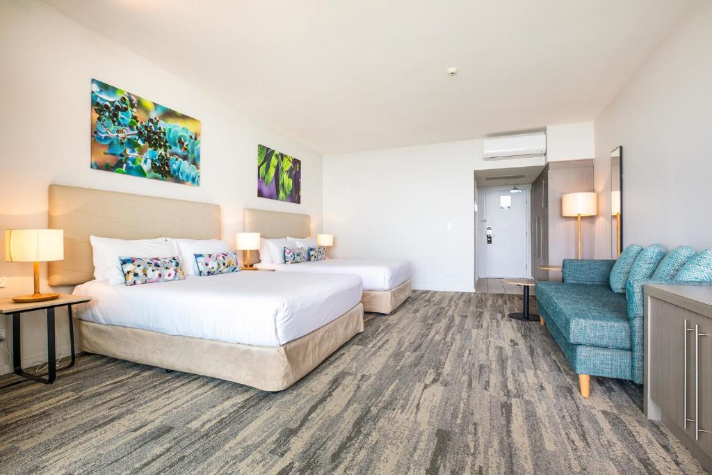 a hotel room with a bed and a couch at Narrabeen Sands Hotel by Nightcap Plus in Narrabeen
