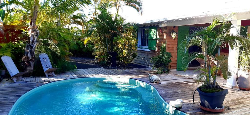 a swimming pool on a deck next to a house at Heliconia Guest House in Étang-Salé