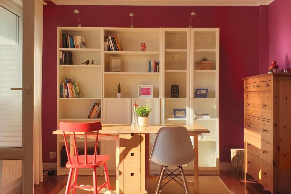 een kamer met een bureau met 2 stoelen en een boekenplank bij SUPERBRIGHT APARTMENT close to BEACHES & METRO in Urduliz