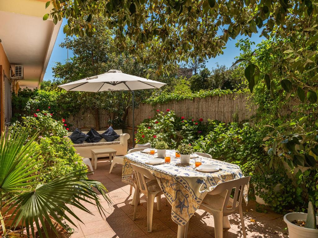 een patio met een tafel en een parasol bij Poetto seaside in Cagliari