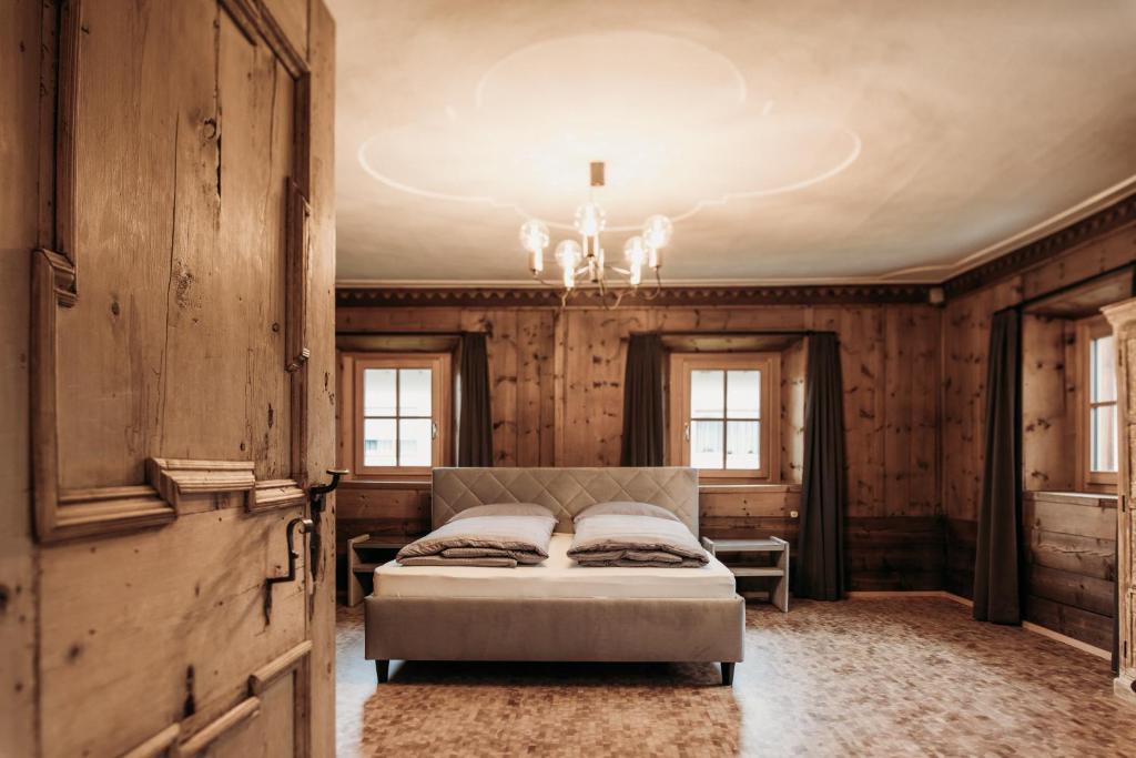 a bedroom with a bed and a chandelier at Ban Hilba in Falzes