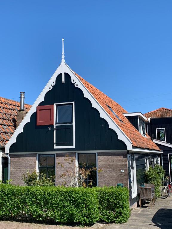 un bâtiment noir avec un toit rouge dans l'établissement Paleis Noordeinde, à Grootschermer