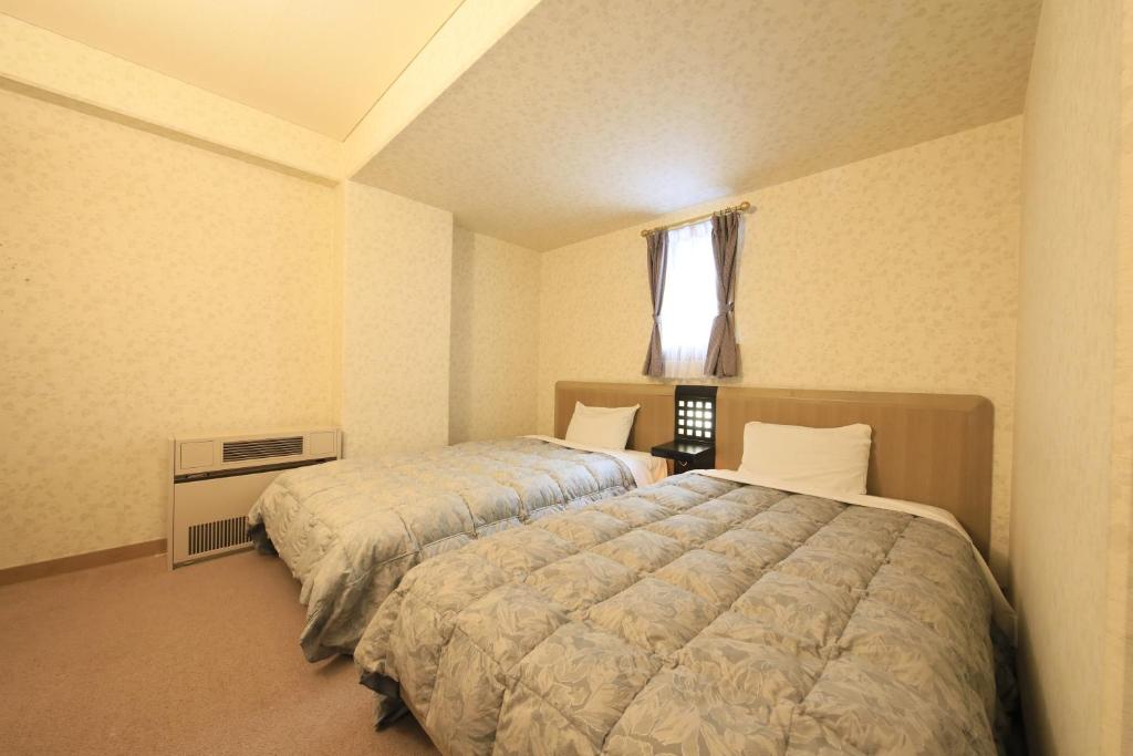 Postel nebo postele na pokoji v ubytování Kishutetsudo Karuizawa Hotel