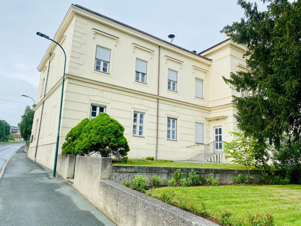 un gran edificio blanco con una luz de la calle delante de él en Haus am Eck, en Rechnitz