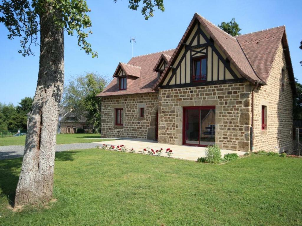 een stenen huis met bloemen ervoor bij Gîte Juvigny-Val-d'Andaine, 5 pièces, 9 personnes - FR-1-497-115 in Saint-Denis-de-Villenette