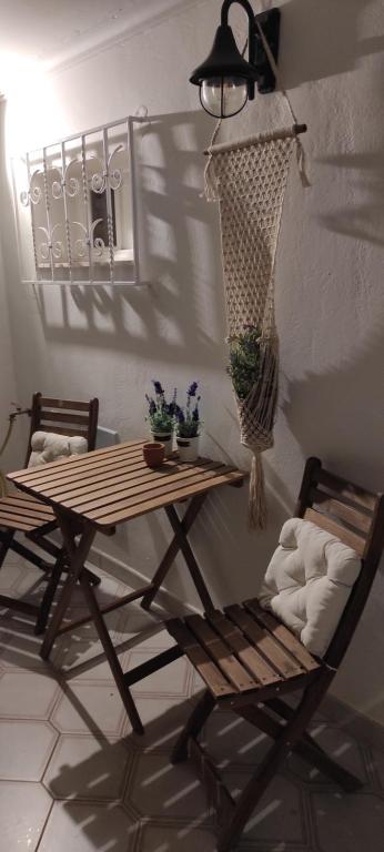 um quarto com uma mesa, uma cadeira e um candeeiro em Zeus Studio on Palamidi foothills em Nafplio